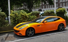 Оранжевый Ferrari FF на обочине у летнего парка